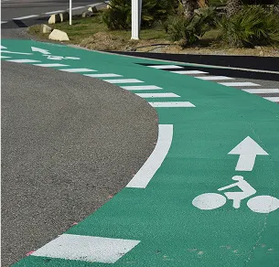Piste cyclable verte avec des flèches et un pictogramme de vélo, longeant la route à Varennes en Indre-et-Loire 37