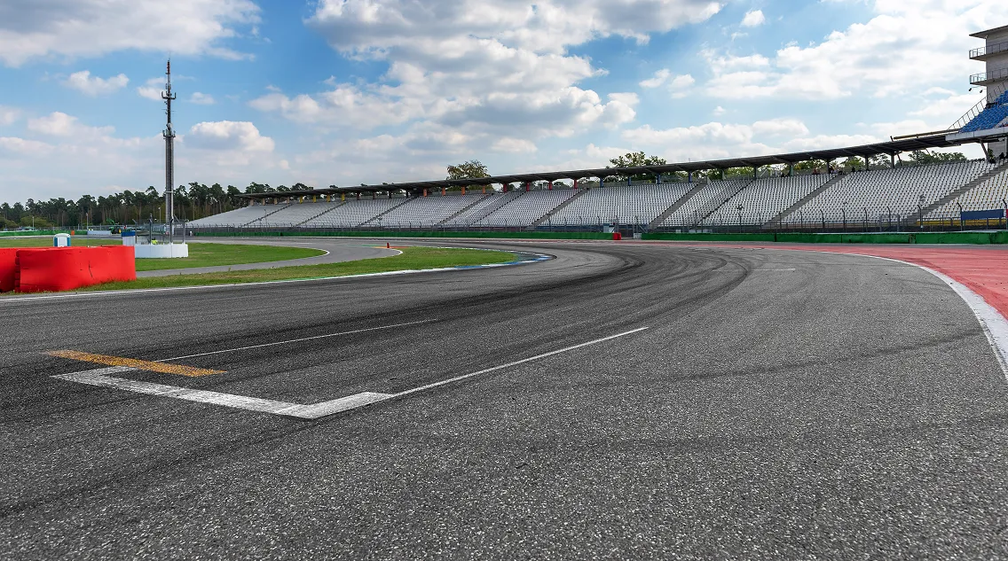 Piste de course automobile vide avec virages, tribunes, ciel nuageux et nature environnante à Varennes en Indre-et-Loire 37