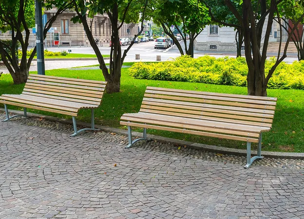 Deux bancs en bois sur un pavé, entourés d'herbe et d'arbres verdoyants à Varennes en Indre-et-Loire 37