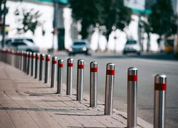 Rangée de bornes métalliques avec des bandes rouges le long d'un trottoir à Varennes en Indre-et-Loire 37