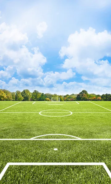 Terrain de football vide sous un ciel bleu nuageux avec des arbres à Varennes en Indre-et-Loire 37